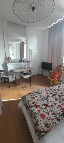 une chambre avec un lit, une table et un miroir dans l'établissement Le secret d'Oscar & la fantaisie de Jean, à Morlaix