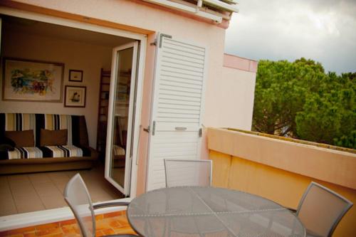 une table en verre et des chaises sur un balcon dans l'établissement Charmant T2 climatisé avec terrasse - 200 m de la plage - les Boramars, à Argelès-sur-Mer
