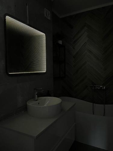 a bathroom with a sink and a mirror and a tub at 12 Apartament in Târgu-Mureş