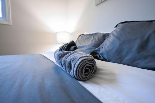 a rolled up towel sitting on top of a bed at The Cozy and Quaint Duplex in Point in Stevens Point