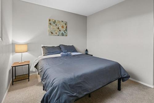 a bedroom with a bed with a blue comforter at The Cozy and Quaint Duplex in Point in Stevens Point