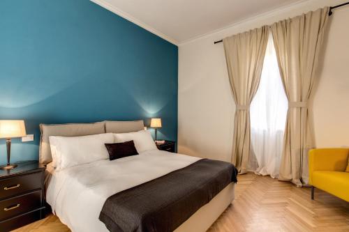 a bedroom with a large bed and a yellow chair at YH SUITE 131 in Rome