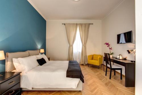 a bedroom with a white bed and a desk and a computer at YH SUITE 131 in Rome