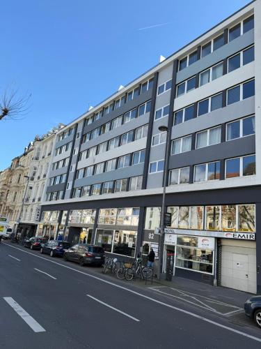 a large building on a city street with parked cars at Hotel Garni Emir in Cologne