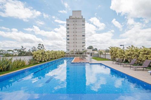 a large swimming pool with a tall building in the background at Studio Moderno Santo Amaro - Perto do Consulado, Transamerica, CGH, Autódromo e Vibra São Paulo in Sao Paulo