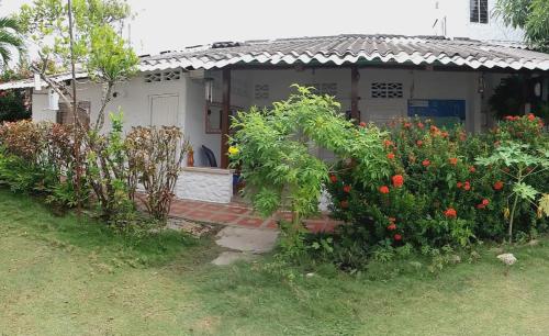 a house with a bunch of flowers in front of it at Hostal del Mar - Tolu in Tolú