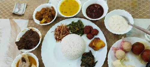 a table with plates of food and bowls of food at Balaji Guest House in Jhārgrām