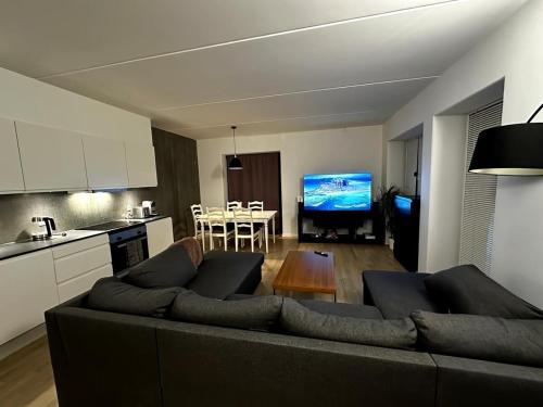 a living room with a couch and a table and a kitchen at Two-story four-room apartment in Copenhagen