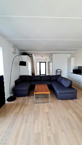 a living room with a blue couch and a table at Two-story four-room apartment in Copenhagen