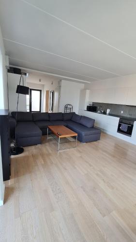 a living room with a blue couch and a table at Two-story four-room apartment in Copenhagen