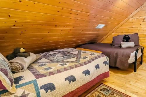 a bedroom with a bed and a chair in a log cabin at Cozy Cabin Wgame Room, Hot Tub & Creek in Pigeon Forge