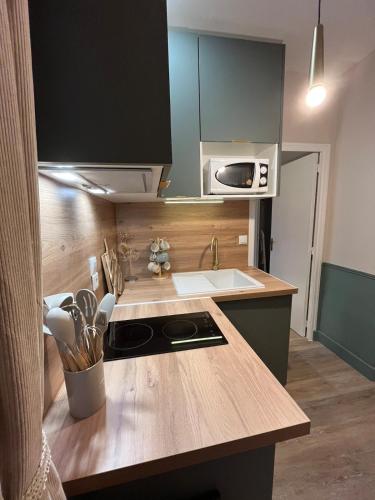 une cuisine avec un comptoir en bois et un évier dans l'établissement Charmant appartement proche centre-ville, à Vannes