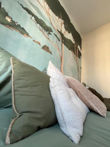 un lit avec deux oreillers et un tableau au mur dans l'établissement Charmant appartement proche centre-ville, à Vannes
