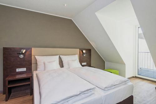 a bedroom with a large white bed and a window at apart N serviced apartments in Nuremberg