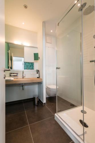 a bathroom with a shower and a sink and a toilet at apart N serviced apartments in Nuremberg