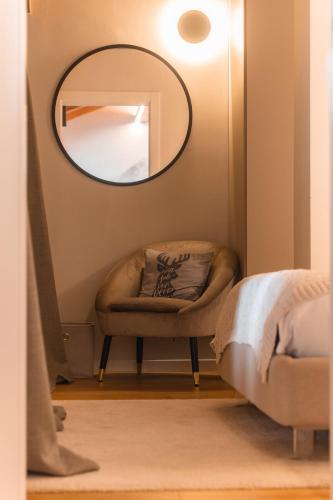 a mirror in the corner of a room with a chair at Suite Boisée - Poluc Apartments Trilocale in Champoluc