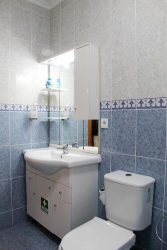 a bathroom with a white toilet and a sink at Waterfall House in Faial da Terra