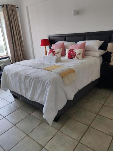 a bedroom with a large bed with pink pillows at 406 Seabrook in Margate