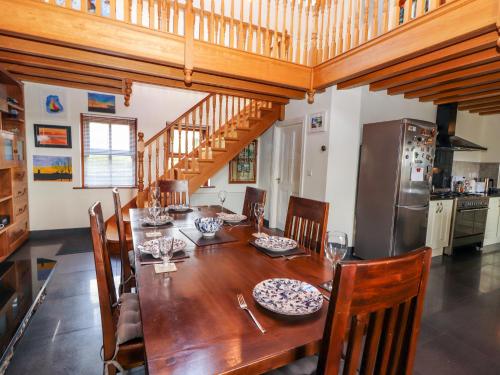 a dining room with a table and a kitchen at Johnson's Cottage in Brandon