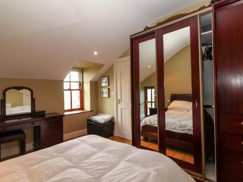 a bedroom with a bed and a desk and a mirror at Johnson's Cottage in Brandon