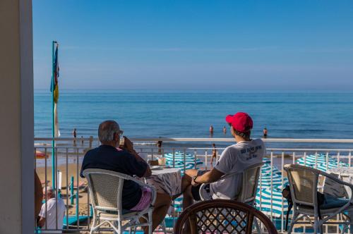 two people sitting in chairs at the beach at Hotel Aurora in Sperlonga
