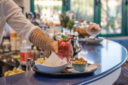 a person preparing food on a table with a plate of food at Hotel Aurora in Sperlonga