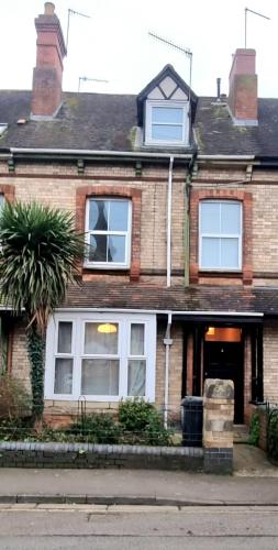 a brick house with a palm tree in front of it at City Stay - free parking in Worcester