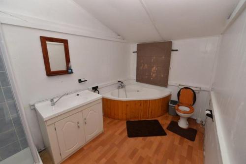 a bathroom with a tub and a toilet and a sink at Self Catering Durban South Coast Sea View IMN Lodge in Bazley Beach