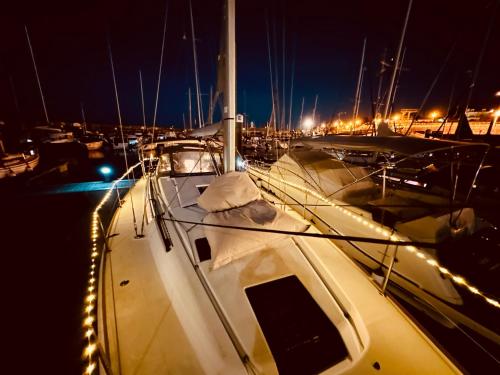 a boat is docked in a harbor at night at Sleep aboard a modern sailboat in Oeiras in Oeiras