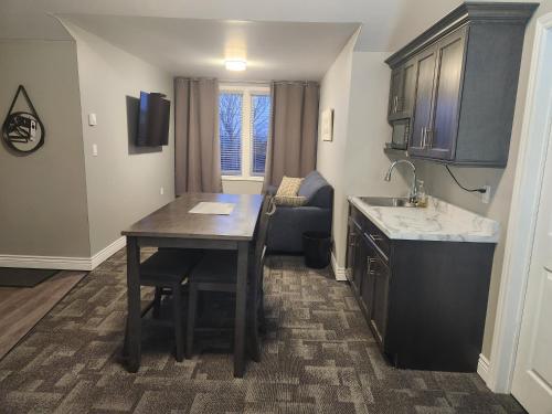 a small kitchen with a table and a sink at Newfound Inn & Suites in Topsail