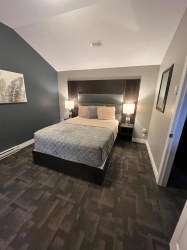a bedroom with a large bed with two lamps at Newfound Inn & Suites in Topsail