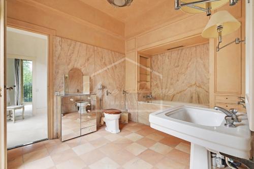 une salle de bain avec une baignoire, des toilettes et un lavabo dans l'établissement Luxurious & Calm Balcony Facing Bois de Boulogne, à Neuilly-sur-Seine