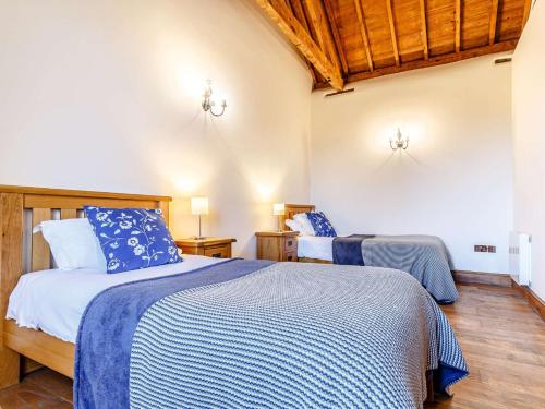 a bedroom with two beds with blue and white sheets at 2 Bed in Launceston 81077 in Saint Giles on the Heath