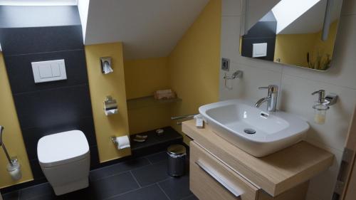 uma casa de banho com um lavatório e um WC em Pension Mühlrad em Herbsleben