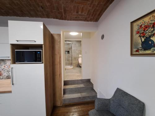 a living room with a staircase and a microwave at Penzion U Cyrila in Moravská Třebová