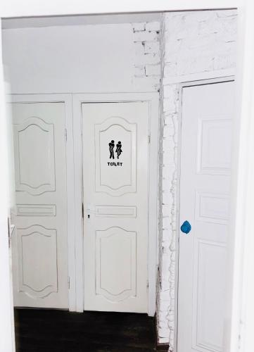 two white doors in a room with white bricks at Mouse House in Chişinău