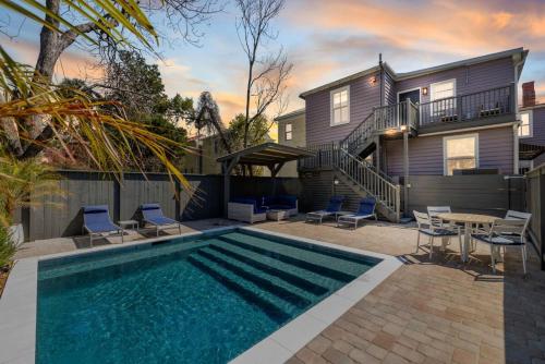 a swimming pool with chairs and a table and a house at Private HEATED Pool Oasis 4 Bedroom Suite in Charleston
