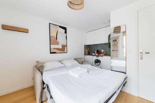 une chambre blanche avec un lit et une cuisine dans l'établissement Studio love agreable Marais paris 3 - 2P, à Paris