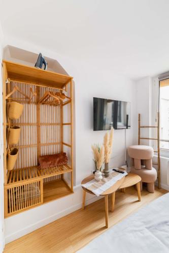 un salon avec une table et une télévision dans l'établissement Studio love agreable Marais paris 3 - 2P, à Paris