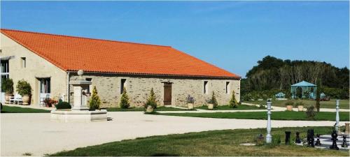 un grand bâtiment avec un toit orange et une cour dans l'établissement Les ALLEES DE TERRE-NEUVE, à LʼÎle-dʼOlonne