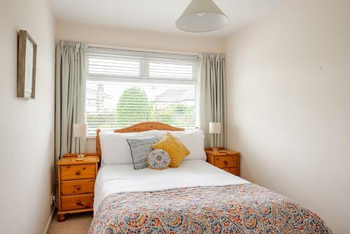 a bedroom with a large bed and a window at The Burrow, a Spacious Bungalow in Heart of NI in Templepatrick