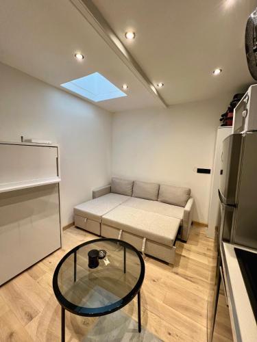 Cette petite chambre comprend un lit et une table en verre. dans l'établissement Appartement, à Neuilly-sur-Seine