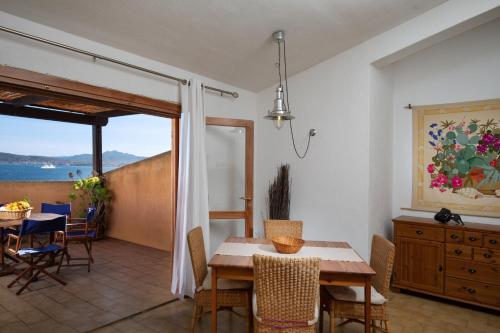 Una cocina y un comedor con mesa y sillas. en Homey Experience - Attic Panorama, en La Maddalena