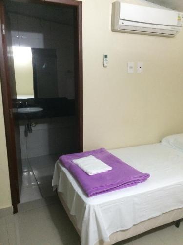 a room with a bed with a mirror and a sink at Pousada Verdes Flores in Brasilia