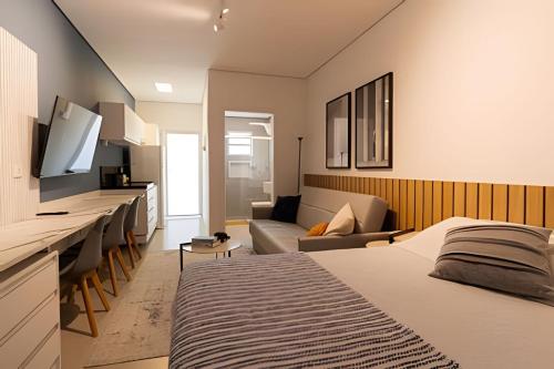 a bedroom with a bed and a living room at Pousada na praia Peruibe - Vila Thaynara in Peruíbe