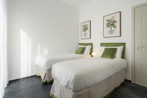 two beds in a room with white walls at Rinascimento Apartments in Florence