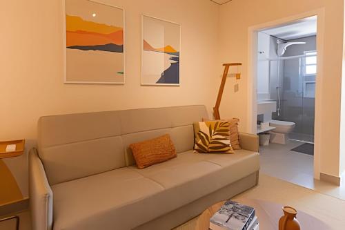 a living room with a couch and a bathroom at Pousada na praia Peruibe - Vila Thaynara in Peruíbe