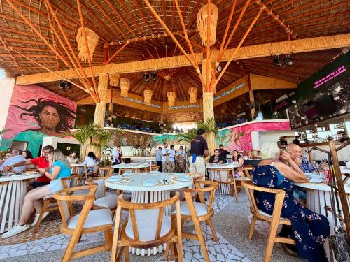 a group of people sitting at tables in a restaurant at Suite CasaBlanca Grand, la mejor vista de Acapulco in Acapulco
