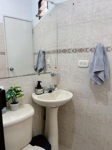 a bathroom with a sink and a mirror and a toilet at apartamento en la floresta in Medellín