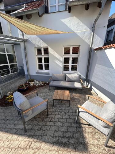 a patio with a couch and chairs and a table at Ferienhaus Niederrhein Kalkar - Traumhaus in klein am Niederrhein in Kalkar